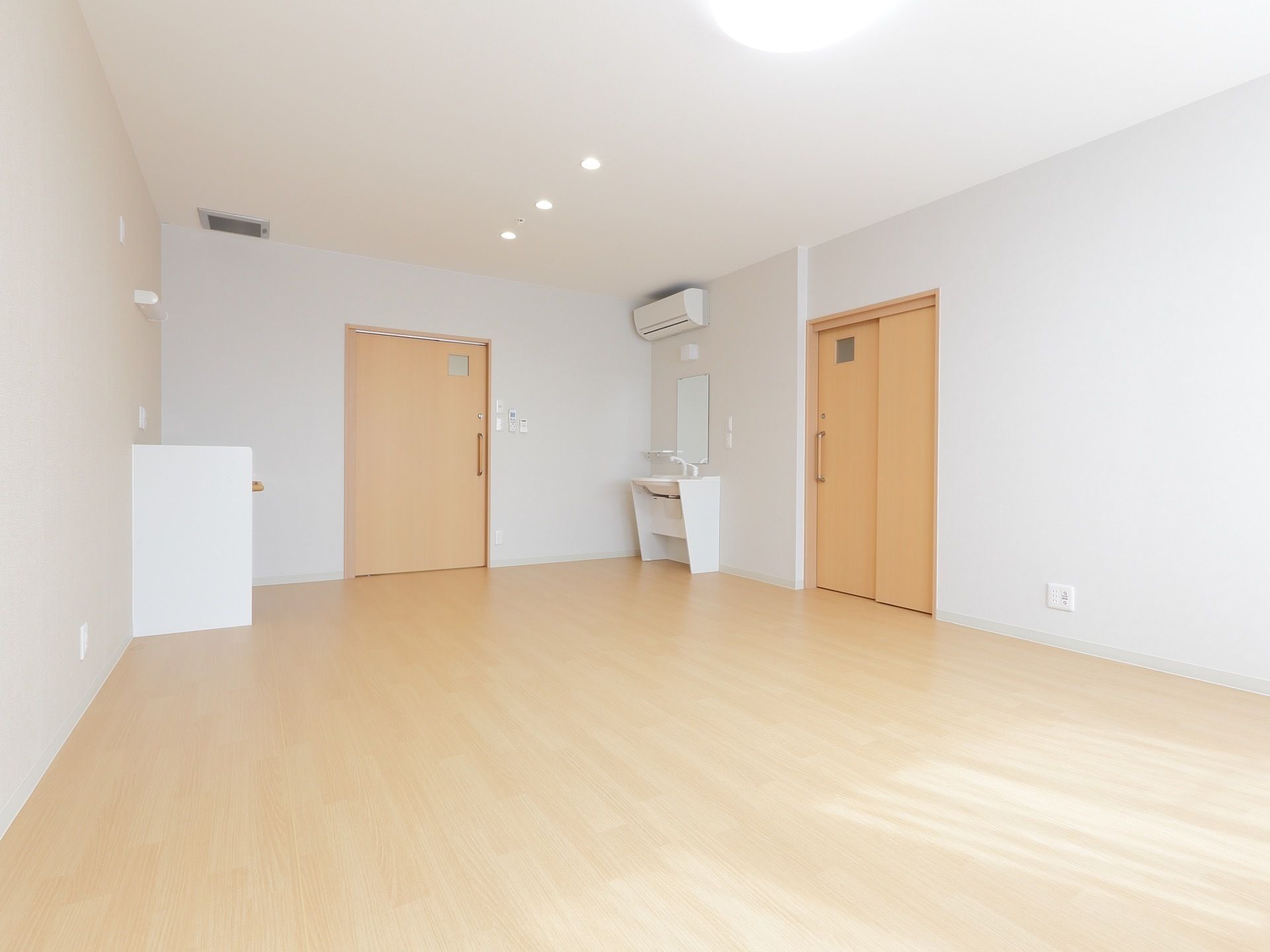 広々としていて、白を基調とした居室内には洗面所とエアコン、トイレが完備されている。床はフローリングでバリアフリー構造である。