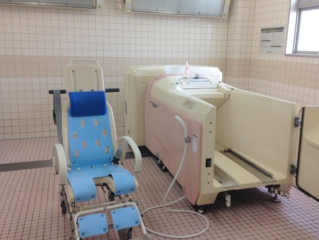 入浴介助が必要な方のための設備が整った、広いタイル貼りの浴室