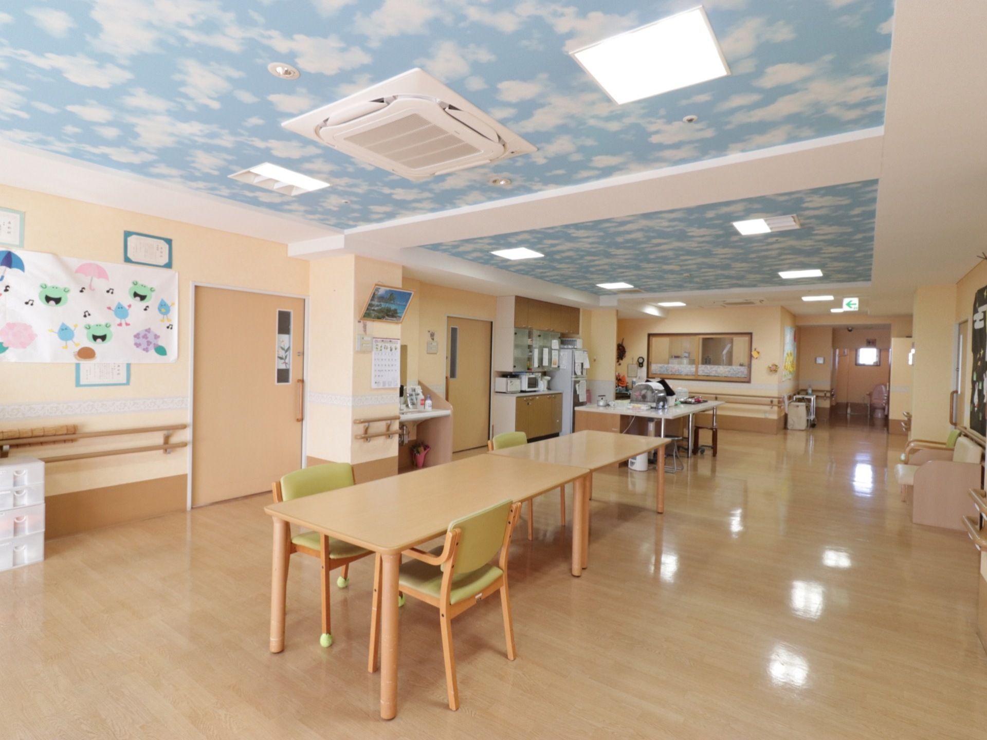 天井には空を模した絵があり、エアコンや照明も付いている。中央には長テーブルが置かれており、その周りには椅子が置かれている。