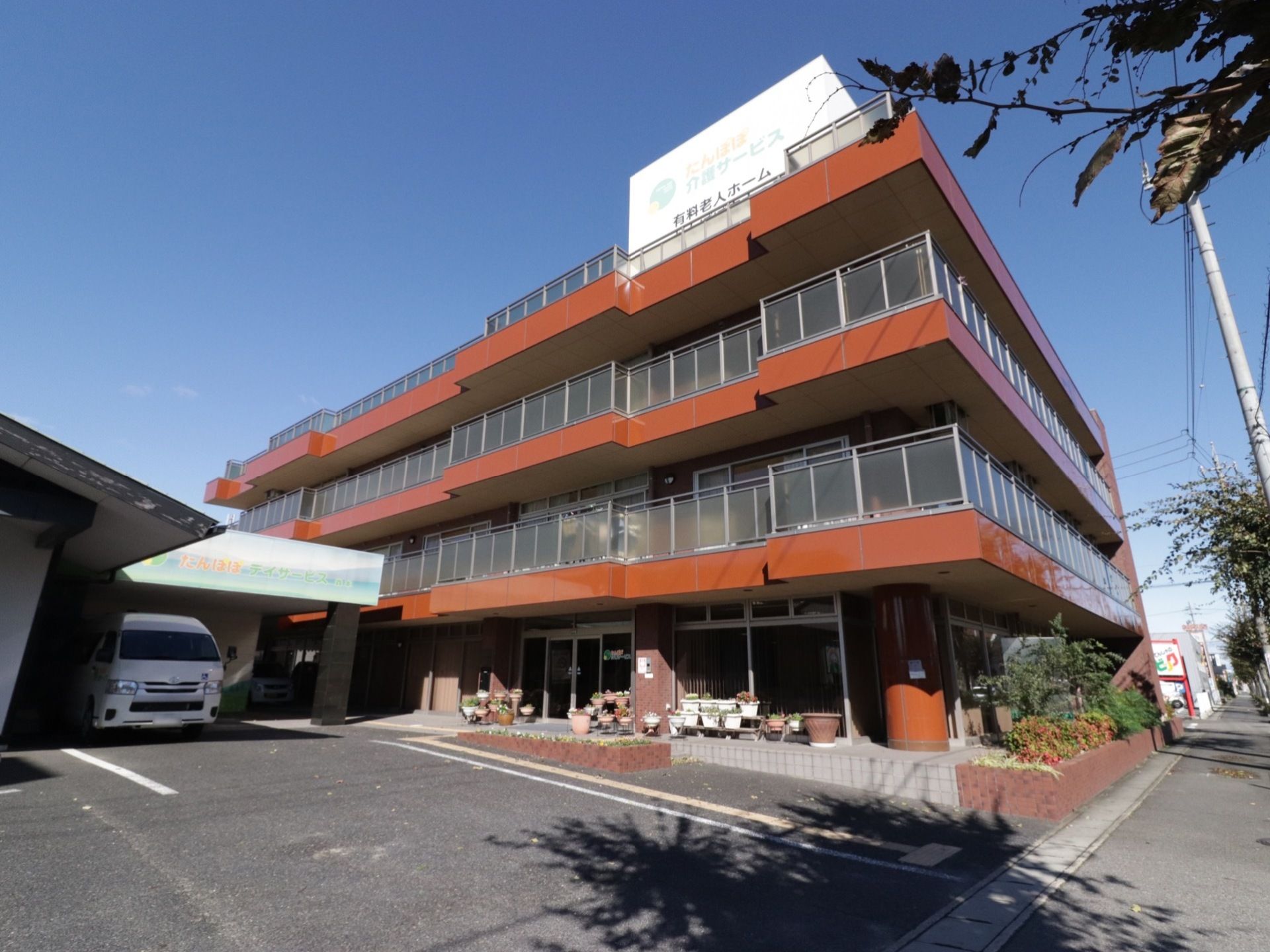 赤茶を基調とした建物。全ての部屋にベランダが設置されている。歩道に面した部分には煉瓦で囲まれた花壇がある。