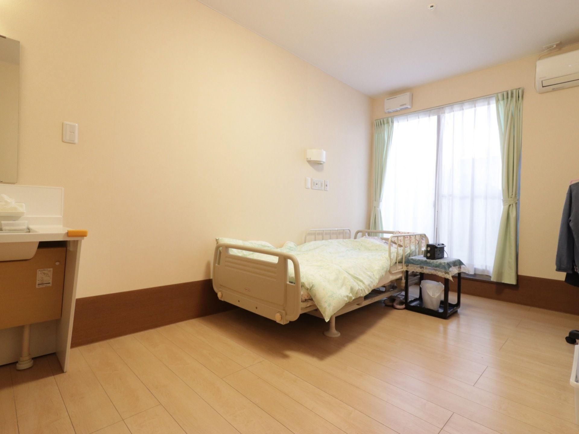 玄関側に洗面台があり外出から戻ってきてすぐに手洗いができ衛生的である。洋間の部屋になっていてベッドがあるので、膝に負担をかけずに生活できる。