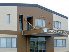 2階建ての建物になっている。ベージュを基調とした外壁で明るい雰囲気があり、窓が多く採光も十分である。