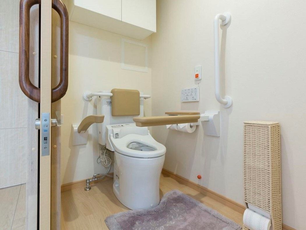トイレは広く、安定した姿勢を保てるように背もたれや手すりがついている。ナースコールも設置してあるので安心して使用できる。