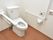 トイレットペーパーホルダーの上にパネルがあり、洗浄もボタン1つで操作ができる。手すりの片側は上に可動する。