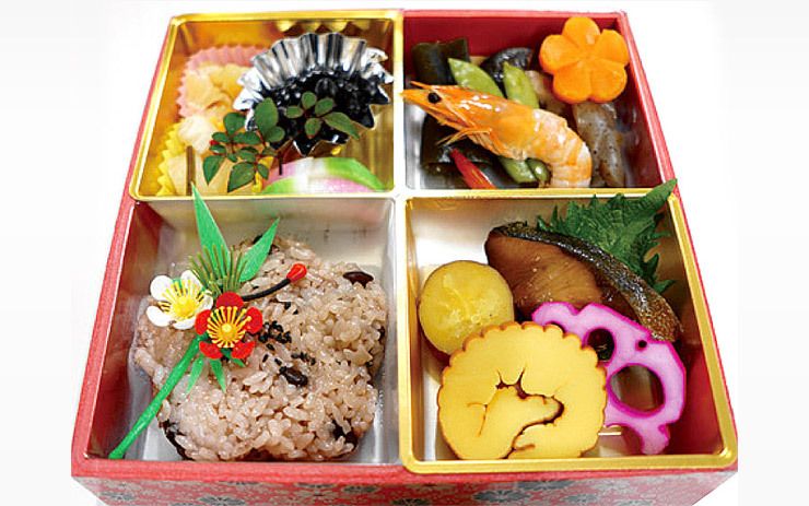 赤飯と海老や黒豆、たまご焼きと焼き魚、野菜の煮物の入った弁当