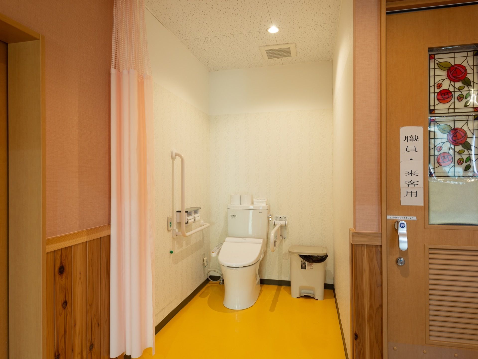 カーテンで仕切られた広々としたトイレである。車椅子をご利用の方も余裕を持って安全に移動することができる。