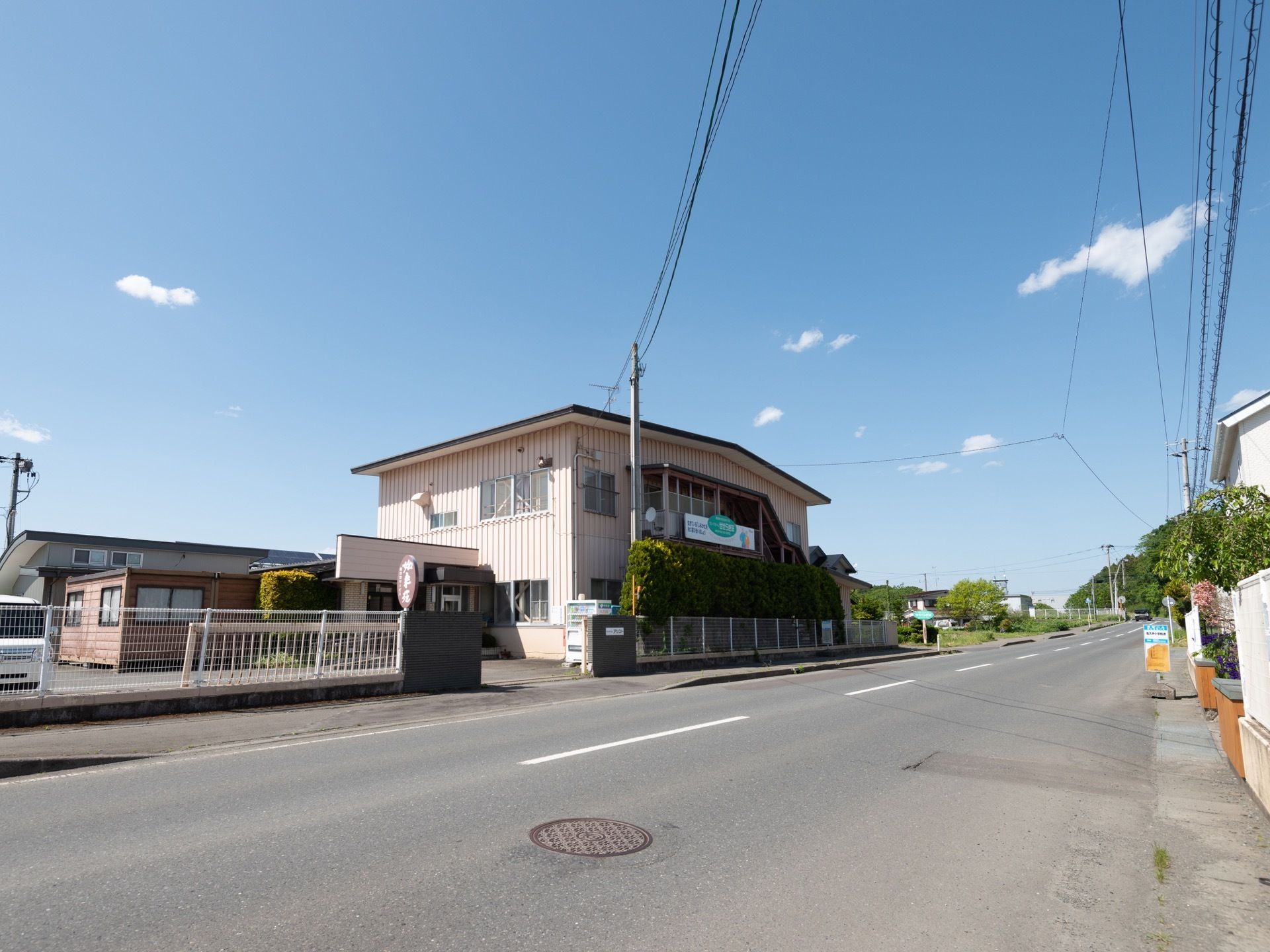 家庭的な雰囲気の施設外観である。閑静な住宅街に位置しており、道路に面しているため目立ちやすい。敷地内には駐車スペースが完備されている。