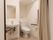 白を基調とした、清潔感のあるトイレである。入り口はアコーディオンカーテンなので力をいれすに開け閉めできる。
