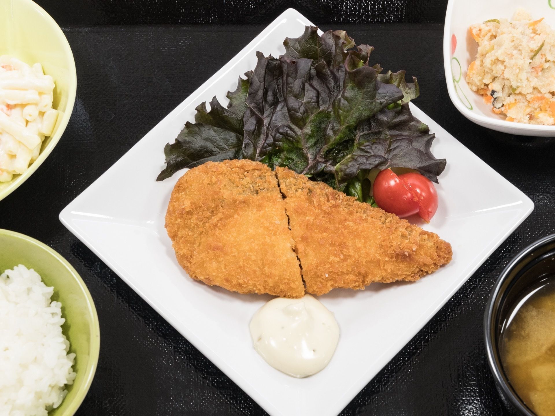 メインは白身魚のフライ、サラダなどの副菜と、白米に味噌汁の一汁三菜の栄養バランスに配慮したメニューの食事である。