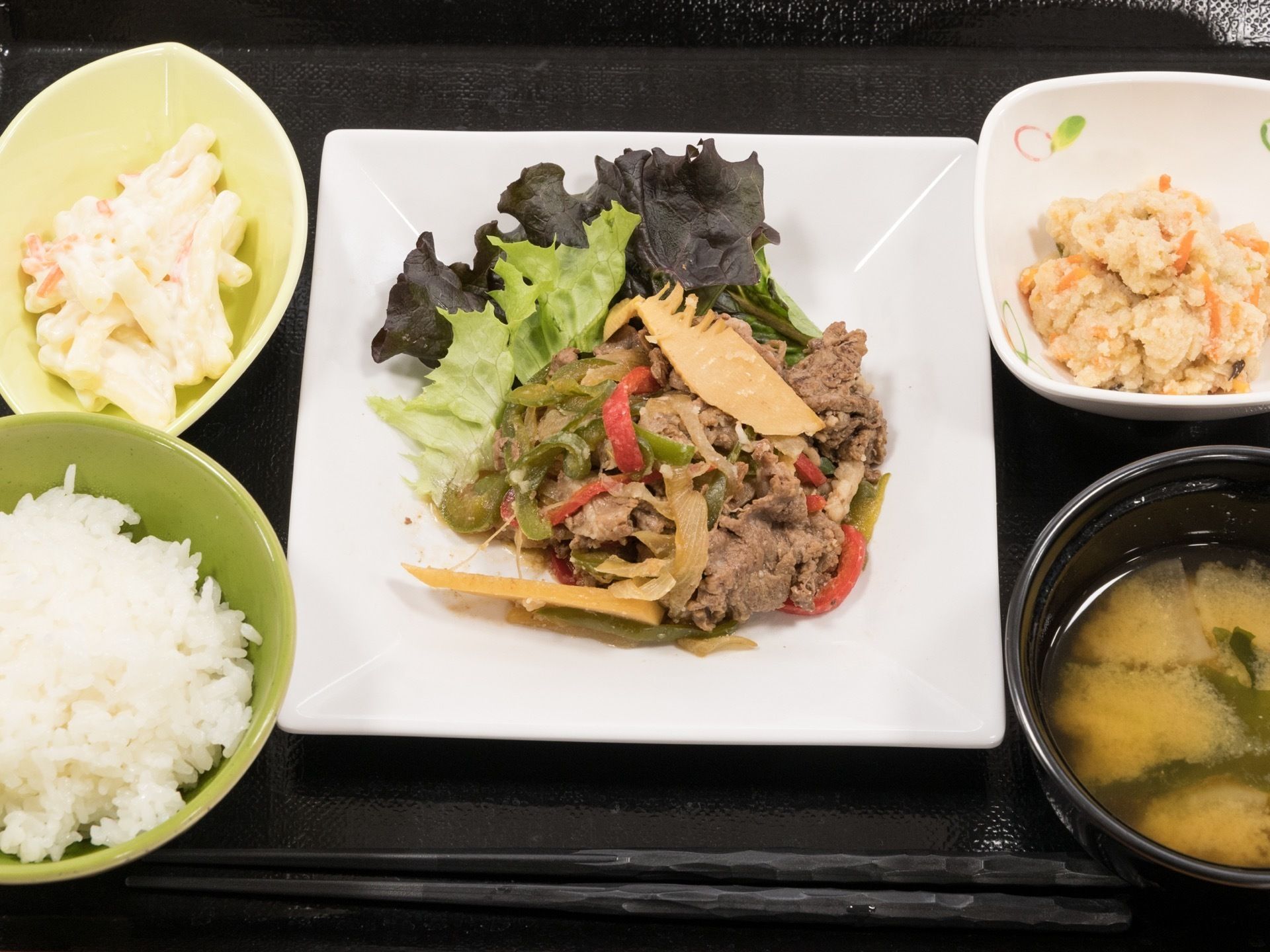 肉野菜炒めと、おからなどの副菜に白米と味噌汁の基本的な和食である。家庭的なメニューで食べやすい食事である。