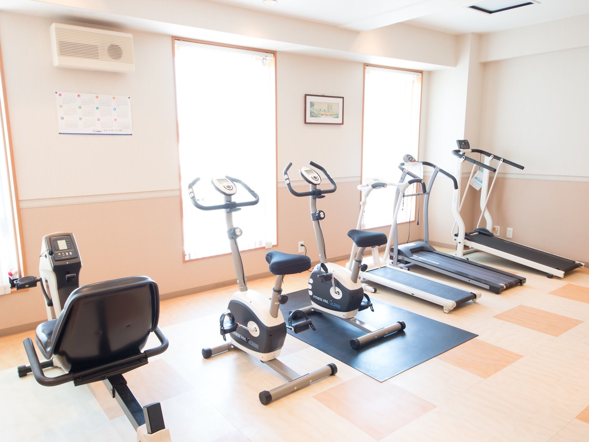 複数の窓が備えつけられ、日差しがたっぷりはいっている。サイクル、ランニングマシンなどのトレーニング機器が完備されている。