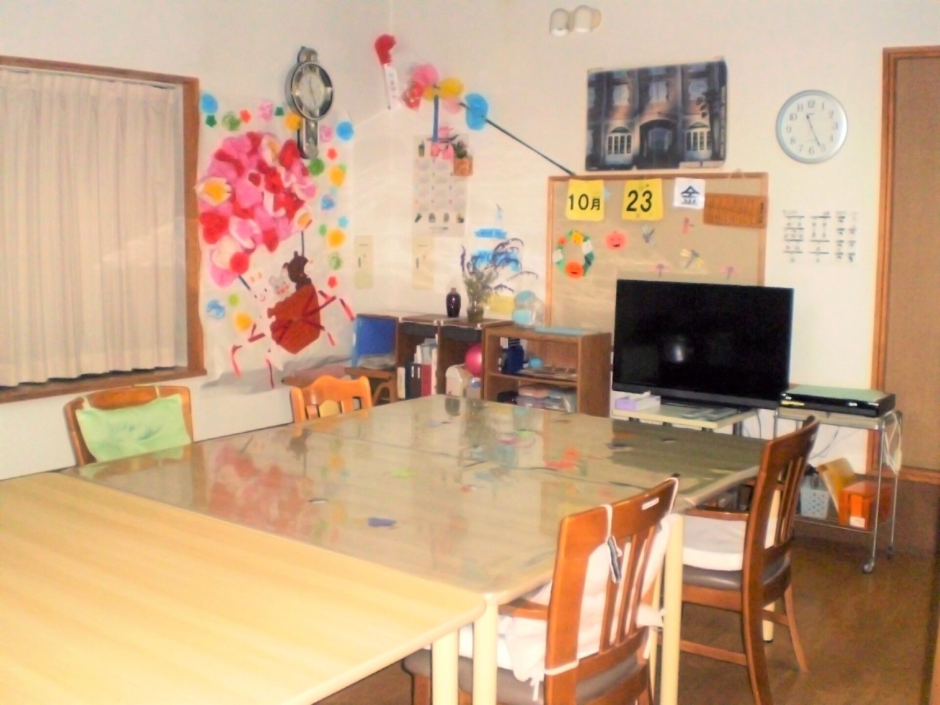 テーブルと椅子があり、壁が色鮮やかに飾り付けされているリビング