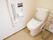 洗浄機能付きのトイレが設置されており、その横には、壁と床にしっかりと固定された手すりが用意されている。