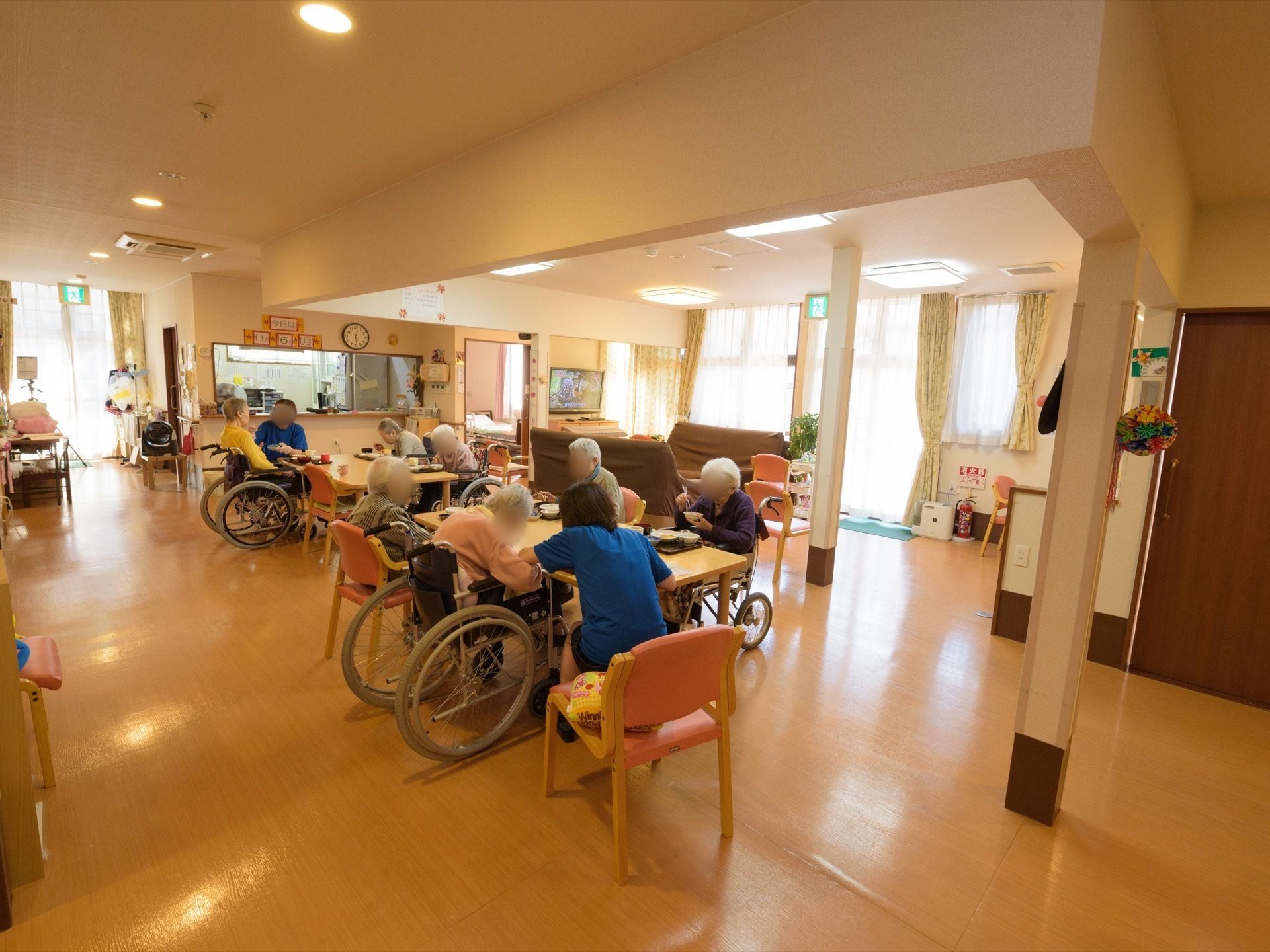 テーブルと椅子が数多く設置されている。入居者様が一緒に食事をとったり、作業をしたりするスペースである。車椅子の方もそのまま席につける。