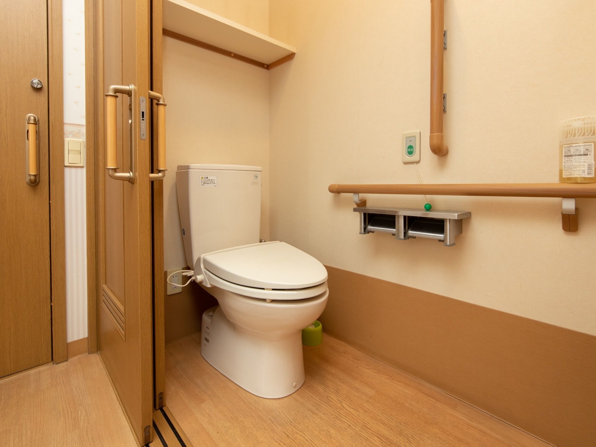 居室に備わっているトイレである。手すりが横にも縦にも設置されているほか、緊急時呼び出しボタンもある。