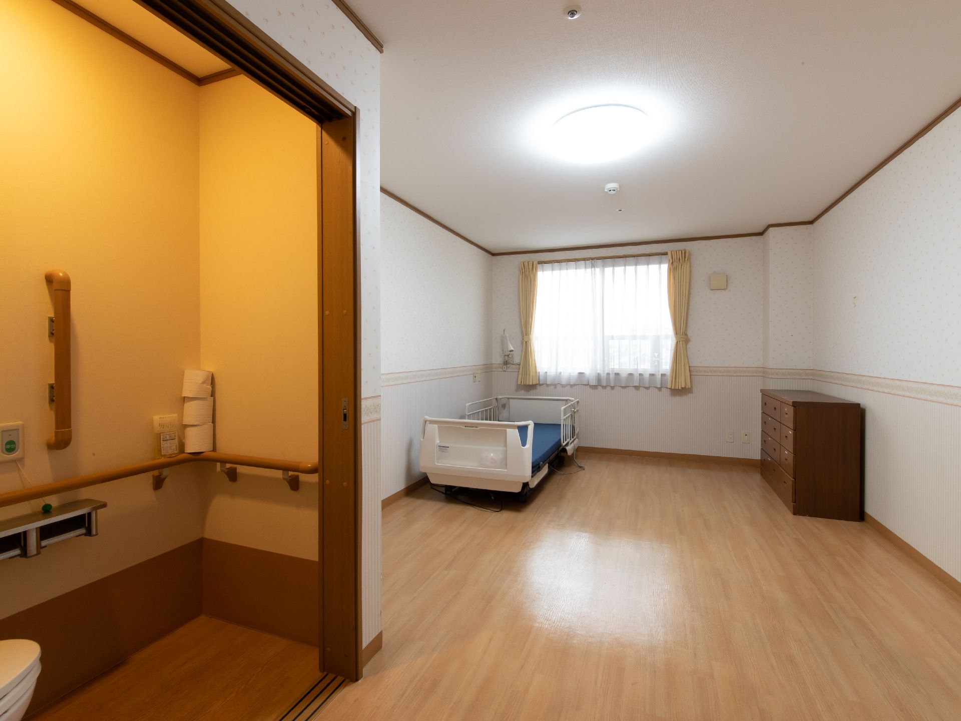 扉が大きく開く個室のトイレが設置されている、広い居室
