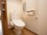 個室トイレの扉は引き戸になっている。洋式便器の左横にはＬ字型の手すりやタオルハンガーがつけられている。
