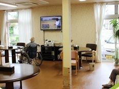 広く開放的なフロア内にテーブルや椅子などが不規則に置かれている。奥にはサイドボードがあり、その上に壁掛けテレビが掛かっている。