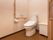 トイレ横の壁には手に優しい木の手すりが設置されている。手が届きやすい位置に、操作用ボタンと緊急ボタンも取りつけてある。