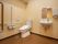 広い共用トイレがある。便座横には操作ボタンに緊急ボタン、手すりが設置してある。中に洗面台もあるので、便利に利用することができる。
