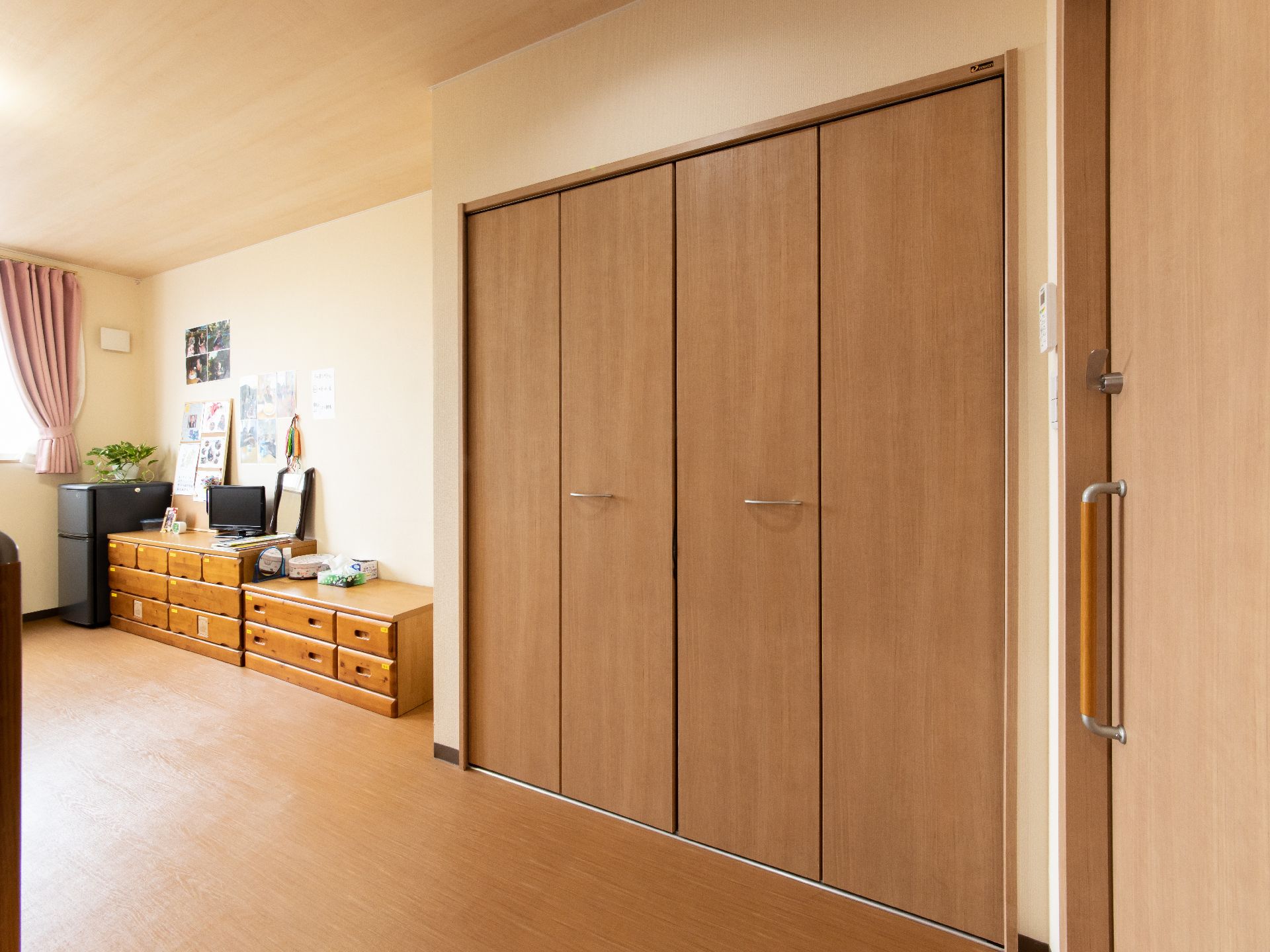 木製扉の大きいクローゼットが壁に建てつけられている。両側に大きく開閉するので見やすさ、出し入れのしやすさがある便利な収納である。