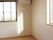 白い壁にフローリングの部屋となっている。窓が２カ所にあり明るい室内である。窓の横にはエアコンが設置されている。