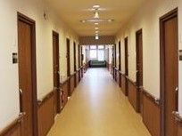 居室入口や壁の下側の茶色の建具が使われている、見通しのよい廊下