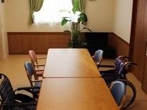 室内は白とブラウンを基調とした落ち着いた空間となっている。テーブルの近くにはさまざまな形の椅子が配置されている。
