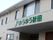 集合住宅のような建物のエントランスに、施設のロゴマークが描かれている。グリーンの色合いと優しい文字が親しみやすい印象になっている。