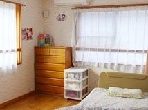 コーナー部に６段の引き出しがついた衣類収納棚が置かれている居室