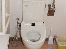 トイレは白を基調としており清潔感がある。入居者様がお一人でお使いの際に、安全に立ち座りしやすいように手すりを完備している。