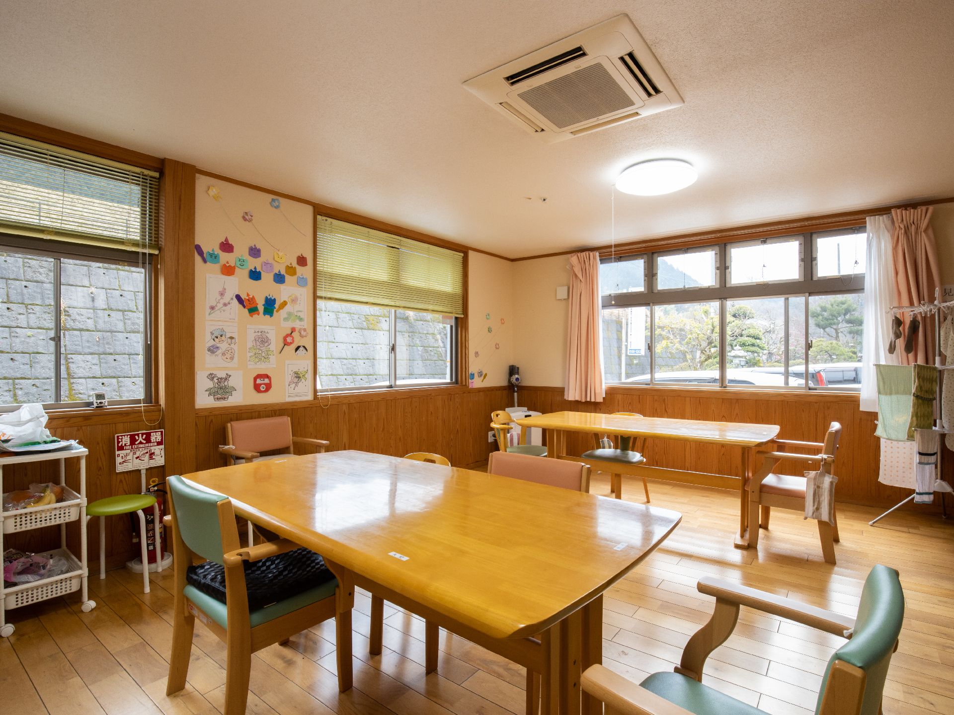 床もテーブルも木で、ぬくもりのある空間である。窓から陽光がたっぷり入るので明るい。壁面には手作りの飾りが貼られている。