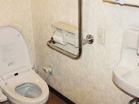 清潔感のある白を基調としたトイレである。入居者様に使いやすいように、トイレ内に手すりや手洗い場を配置している。