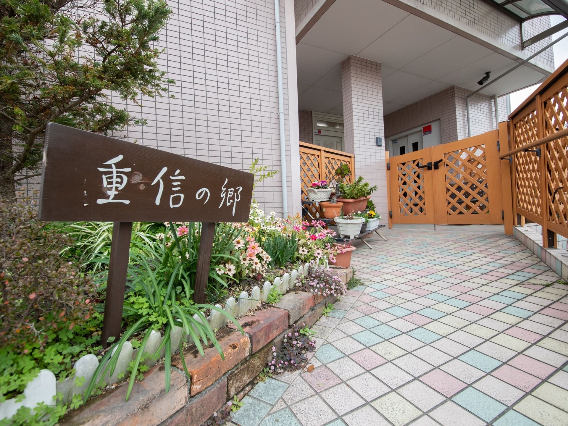 玄関の脇にガーデニングコーナーがある。プランターや地面にたくさんの花が植えられている。土いじりをして気分転換することができる。