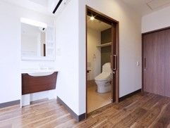 洗面台とトイレが備え付けられた居室である。床は段差のないフローリングの床となっており、扉はスライド式である。