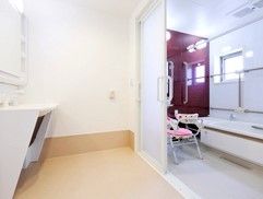 窓がある明るい浴室である。出入り口の扉は大きなスライド式で、安全に開閉することができる。手すりが多く設置されており安全に入浴できる。