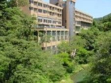 薄い茶色を基調とした外壁を持つ大規模な施設の遠景写真