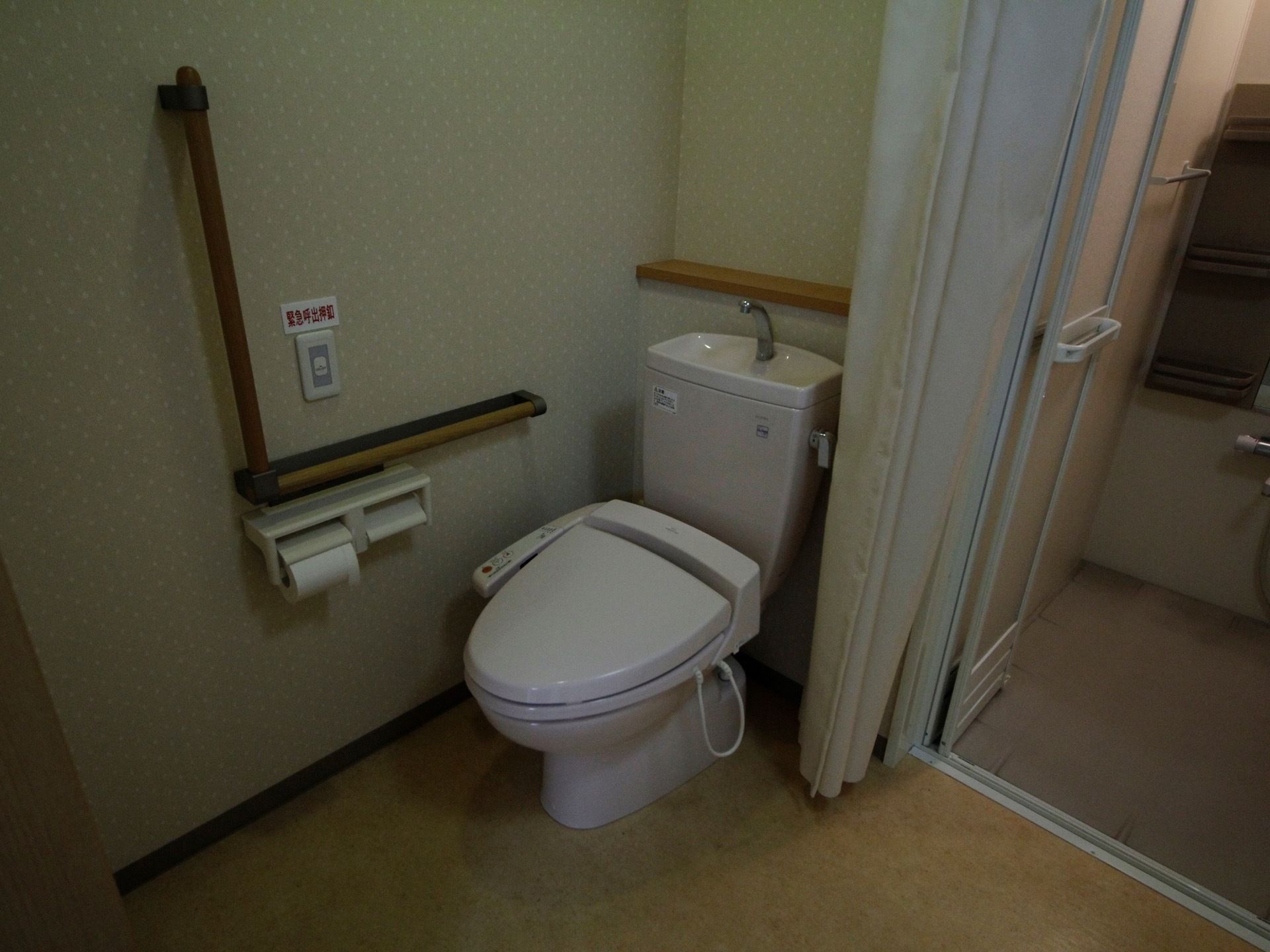 トイレにドアはなく、代わりにカーテンで仕切れるようになっている。後ろのタンクには手を洗う蛇口が付いている。