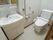 フラットなフロアにトイレと洗面スペースをまとめている。間の壁には移動をサポートする手すりを設置している。