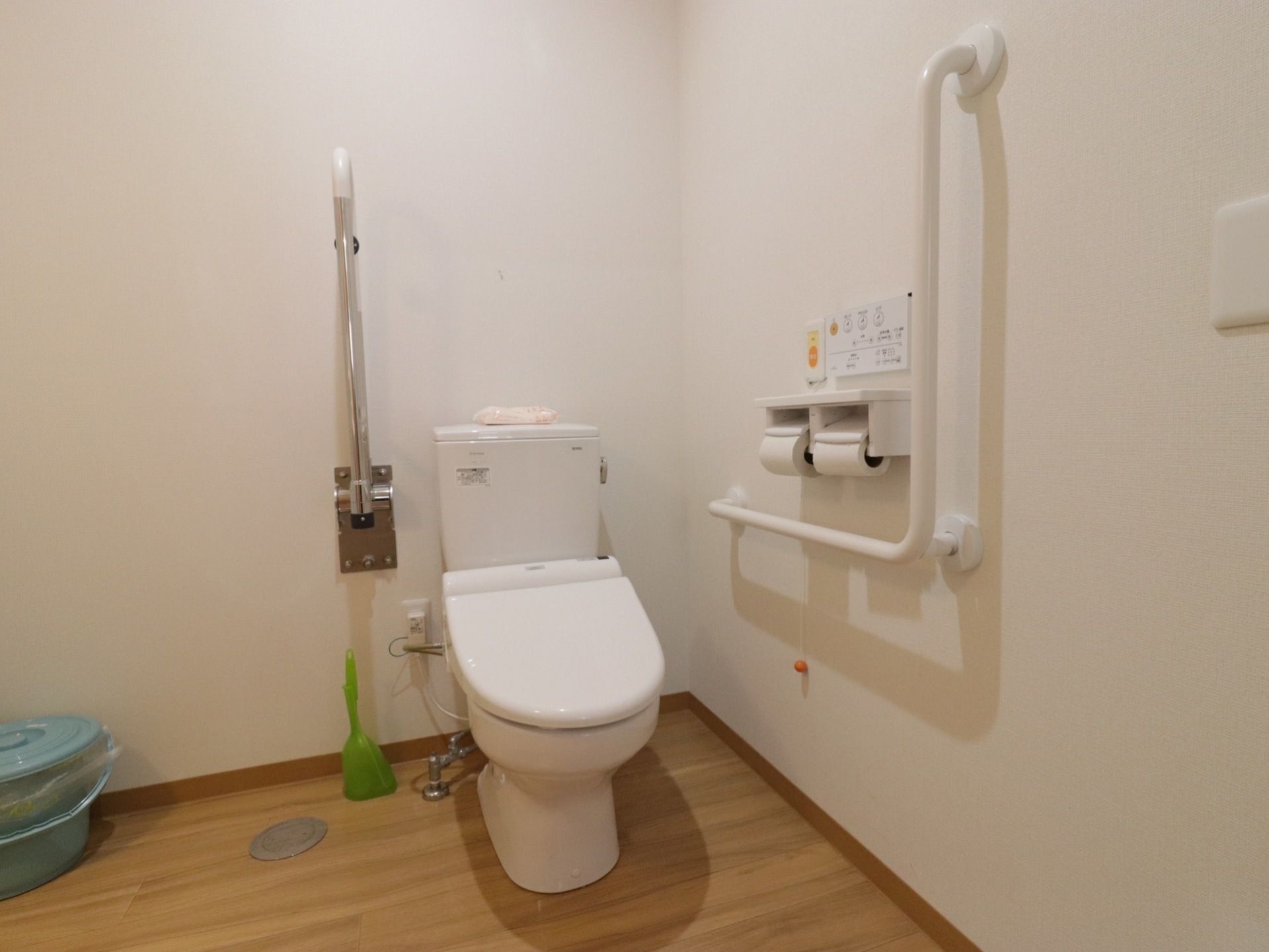 共用のトイレはほぼ居室にある物と同じだが、背中側の壁に折り畳み式の手すりを収納するようになっており、必要な際に利用できる。