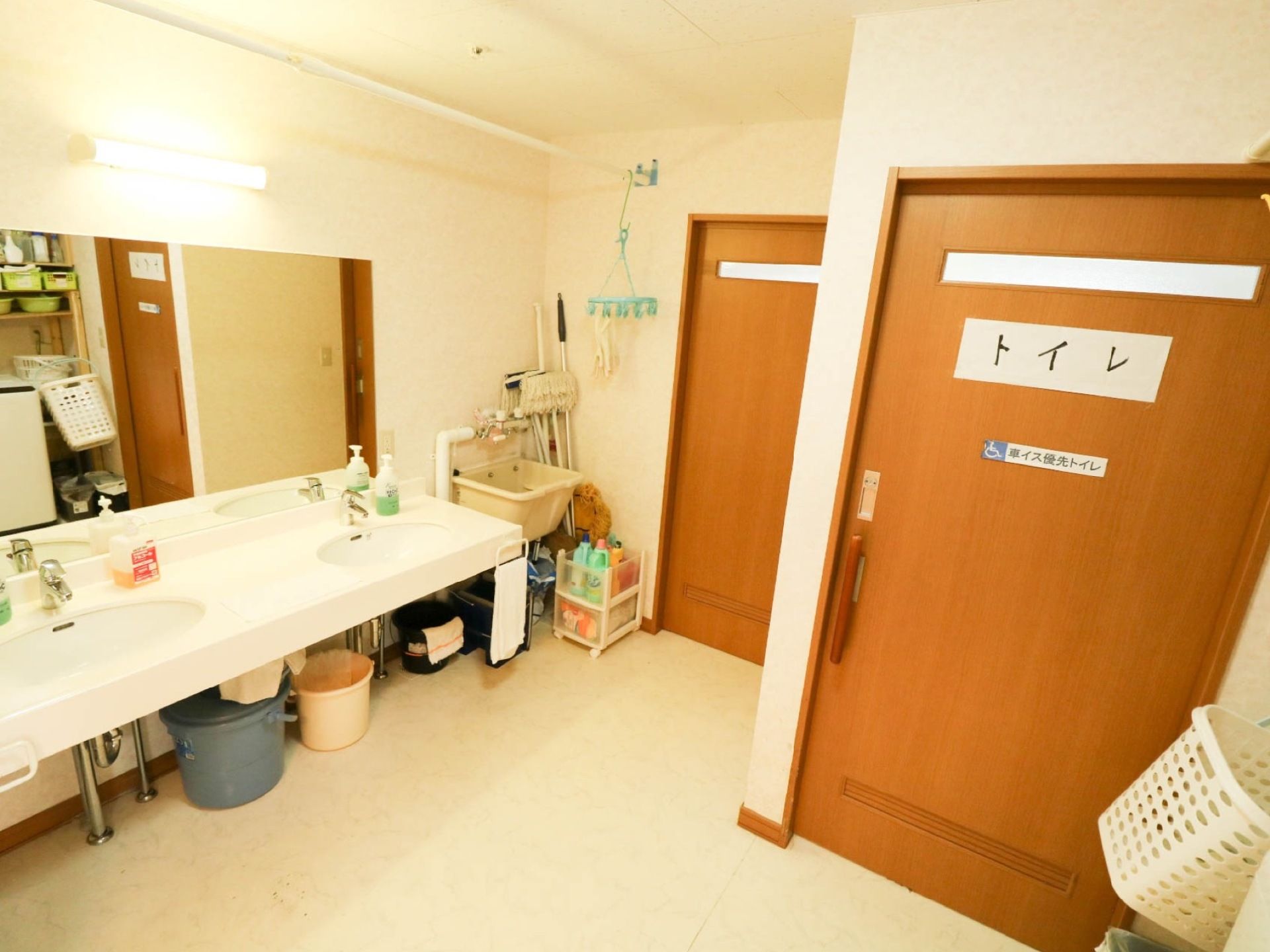 木目調の引き戸で仕切られたトイレがある。１か所は車椅子優先になっており、外には洗面台が設置されている。