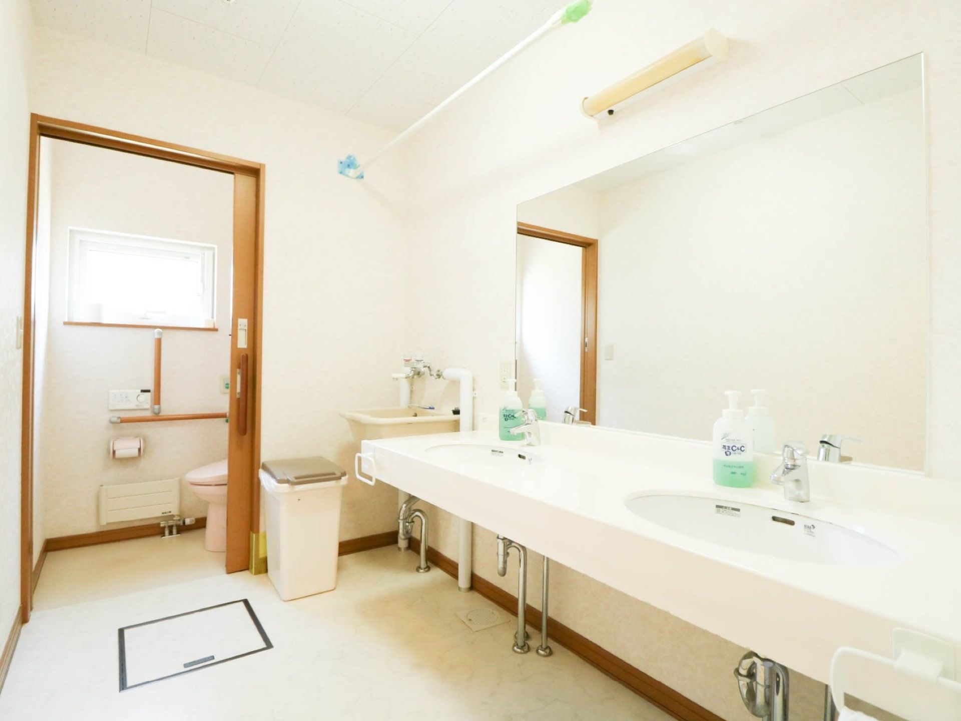 洗面台が２カ所設けられており、その奥にトイレがあり、中には窓があるので明るい。壁には手すりが付いている。