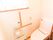 壁に手すりが張り巡らされたトイレがある。やや高い位置に窓が付いており、外光が入って明るい室内になっている。