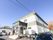 ２階建ての住宅があり、玄関前は階段になっている。階段の脇には手すりの付いたスロープが設けられている。