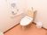 洋式便座のあるトイレである。壁には職員を呼ぶように注意書きが貼られている。ナースコールが取り付けられている。