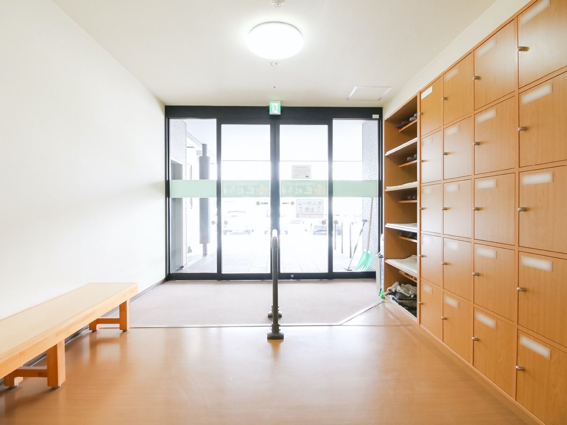風除室から外の駐車場を見たところ。開口部が広いので、とても明るい。エントランスから、廊下まで一直線のバリアフリーになっている。