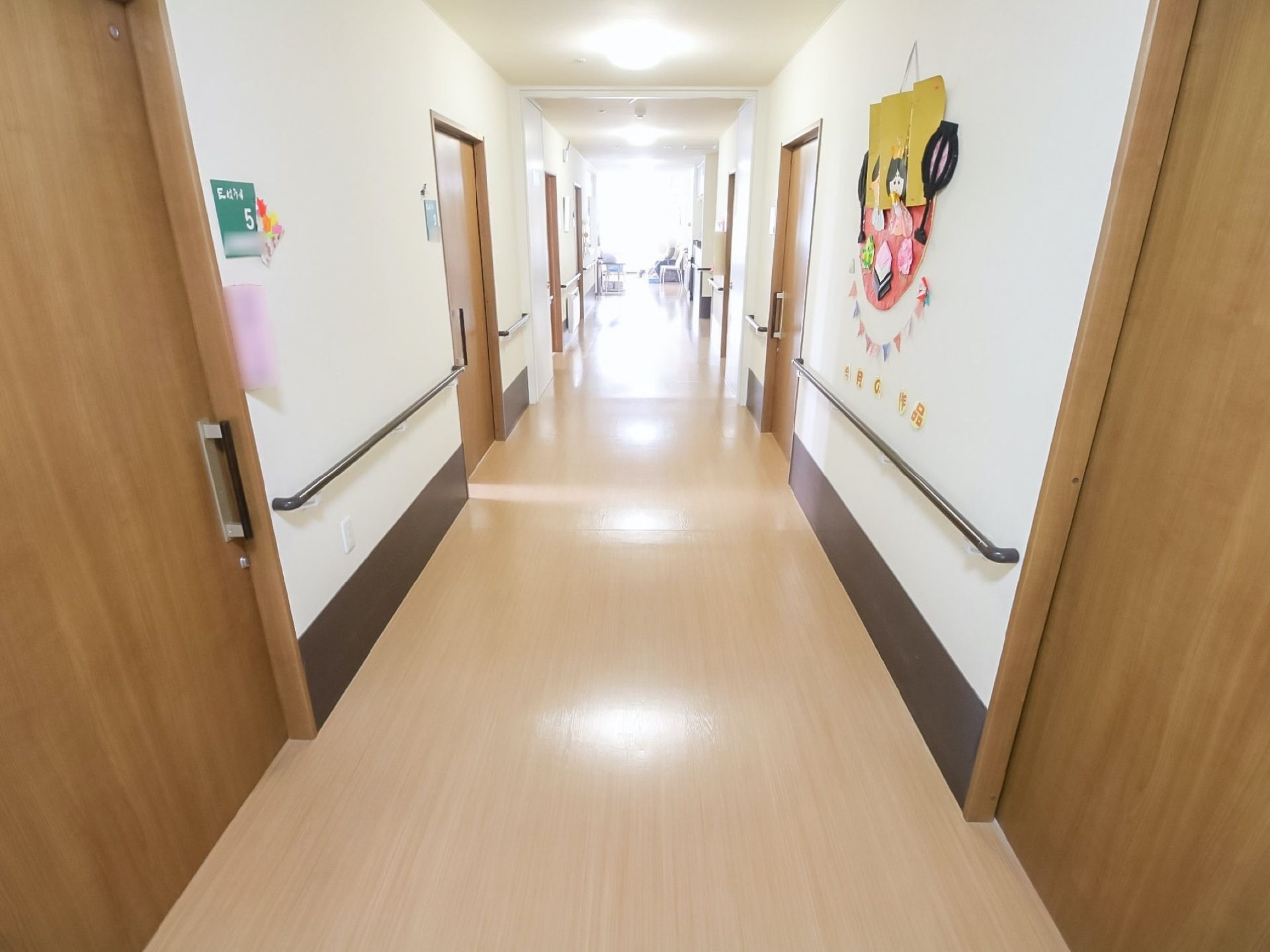 建物を一直線に貫く広い廊下である。照明が数多く設置されており、とても明るい。壁面のところどころに手作り品が飾られている。