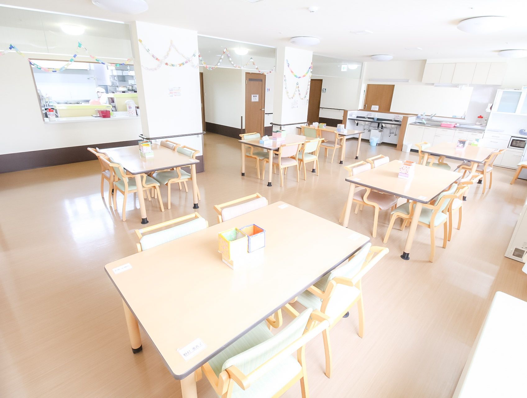 開口部のあるキッチンのすぐ隣にある、明るい雰囲気の食堂
