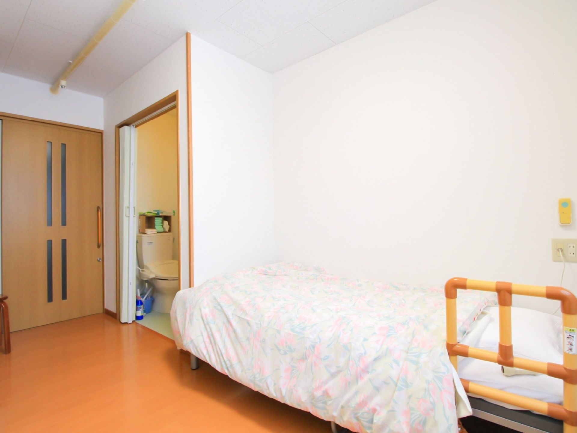居室のベッドは簡易的な手すりも設置されていて、使用しやすくなっている。お一人でのご利用の際も安心して休める。