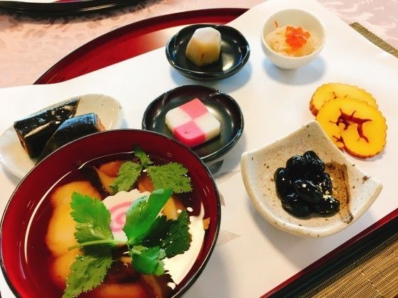 朱色のお盆の上に敷かれた白色の紙の上に並べられているお食事